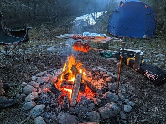 This_image_shows_portable_camping_spit_being_used_during_camping