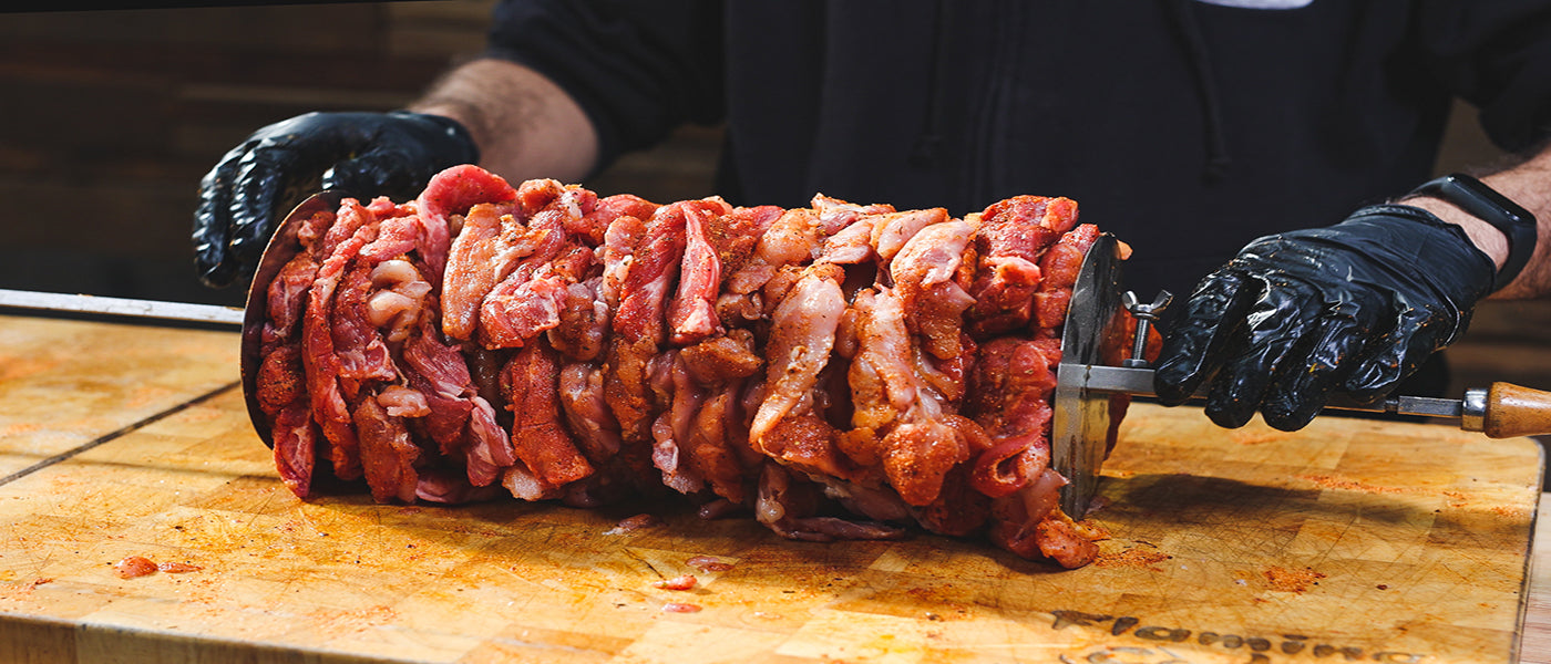 Marinated meat stacked tightly on a rotisserie skewer with gyros discs at both ends, ready for cooking on a spit roaster. Marinated meat stacked tightly on a rotisserie skewer with gyros discs at both ends, ready for cooking on a spit roaster.