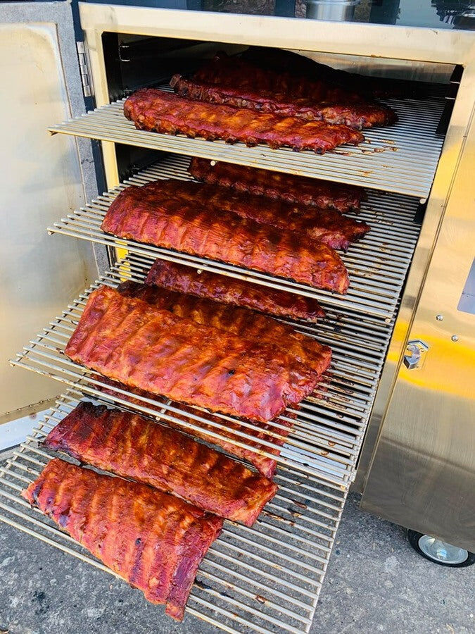  Flaming Coals Gravity Feed Smoker loaded with multiple racks of smoked pork ribs.