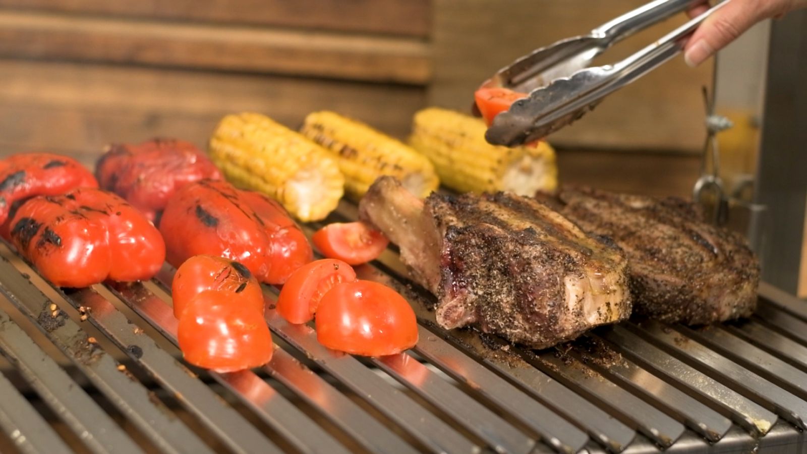 Steak and vegetables cooking on a parrilla grill over charcoal