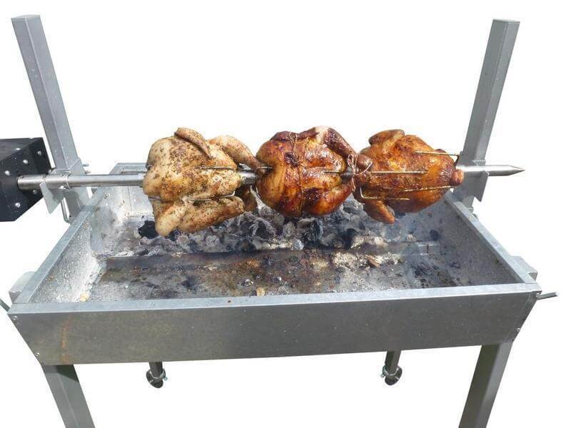 Extendable large charcoal BBQ spit rotisserie cooking three whole chickens over hot coals